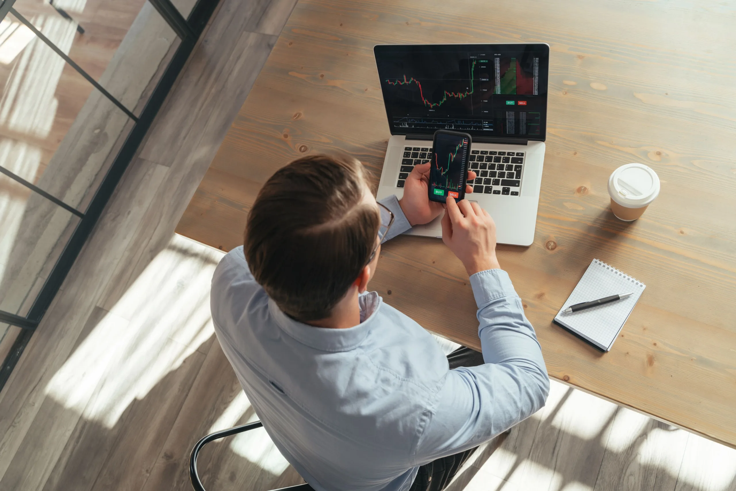 trader office table holding phone showing bitcoin